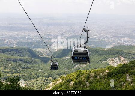 Tirana, Albanien, 8. Juli 2019: 'Dajti Ekspres" Gondelbahn auf den Berg Dajti, mit der Ansicht von Tirana, in Smog bedeckt Stockfoto