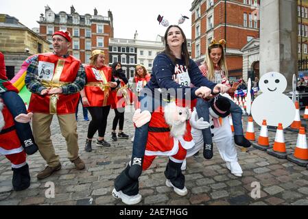 London, Großbritannien. Vom 7. Dezember 2019. Die Teilnehmer warm up vor der 39. grossen Plumpudding Rennen in Covent Garden, die Kapital für Krebsforschung sowie mit vielen festlichen Spaß. Credit: Stephen Chung/Alamy leben Nachrichten Stockfoto