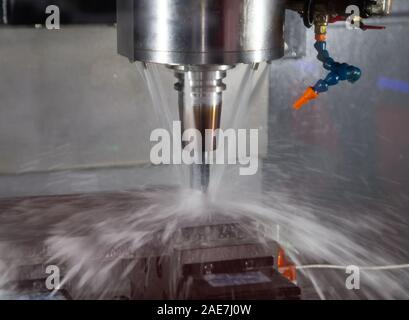 CNC-Fräsmaschine schneiden Werkstück mit Kühlmittel Stockfoto