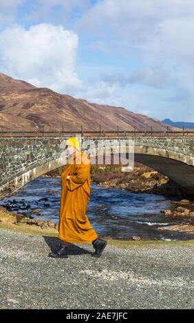 Besuchen Mönch zu Fuß durch die alte Brücke Sligachan, Isle of Skye, Schottland, UK im März Stockfoto