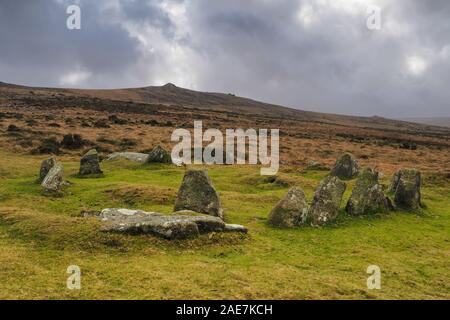 Neun Mädchen Bronzezeit cairn Kreis unter Belstone Tor und stürmischen Himmel, Nationalpark Dartmoor, Devon Stockfoto