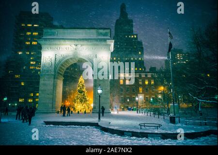 Winterurlaub Nacht Blick auf den Washington Square Park mit einem Weihnachtsbaum unter fallenden Schnee in New York City Stockfoto