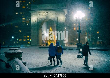 NEW YORK - ca. Dezember 2017: Winter Urlaub Nacht Blick auf den Washington Square Park mit einem Menschen zu Fuß vor dem Weihnachtsbaum unter Fa Stockfoto