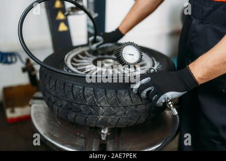 Mechaniker pumpt Rad, Reifen Reparatur Service Stockfoto