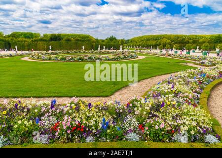 Schöne Sicht auf die latona Parterre in den berühmten Gärten von Versailles an einem Sommertag. Die dargestellten gepflegten Rasen, Blumen, Skulpturen und eine... Stockfoto