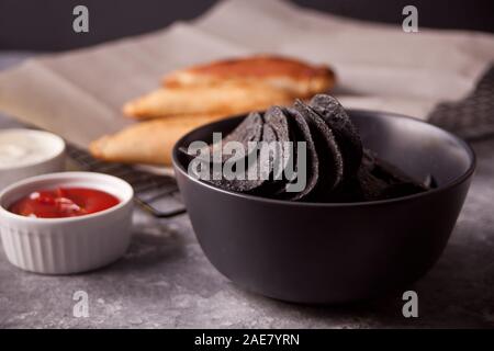 Mexikanischer mais Chips, Nachos und gebratenem Fleisch Torten empanadas cheburek mit Dips. Schwarze Chips, Nachos für brutale Männer Stockfoto