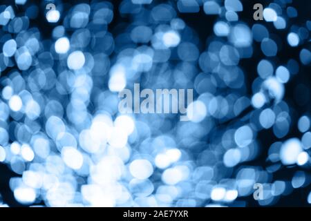 Abstrakte verschwommenen Hintergrund mit zahlreichen hellen festlichen Bokeh in trendigen Classic blau Farbe des Jahres 2020. Feier, urlaub Konzept. Schmierfilm Stockfoto