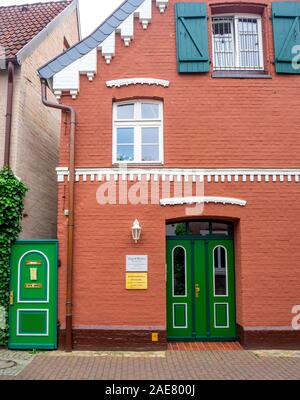 Traditioneller roter Ziegelbau mit bemalter grüner Tür und Tor in Hitzacker Niedersachsen Deutschland. Stockfoto