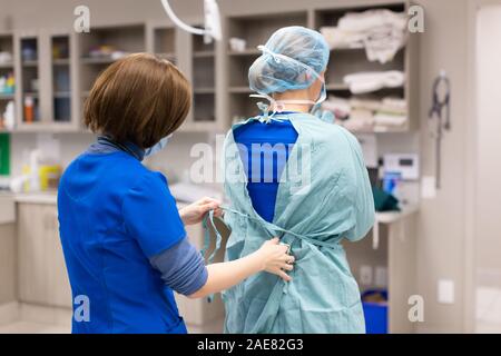 Ein Tierarzt geht durch eine gründliche pre-Chirurgie Praxis der Schrubben und dann gowing für Chirurgie. Stockfoto