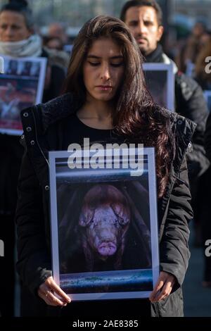 Madrid, Spanien. 7. Dezember, 2019. Eine Frau mit einem Bild von einem Schwein, das die Bedingungen der Tiere in Farmen, protestieren gegen Tierquälerei durch ÔAnimal EqualityÕ (Igualdad Animal), verurteilte die Auswirkungen der industriellen Tierhaltung auf dem Planeten zeitgleich mit der UN-Klimakonferenz COP 25 in Madrid, Spanien. Credit: Marcos del Mazo/Alamy leben Nachrichten Stockfoto