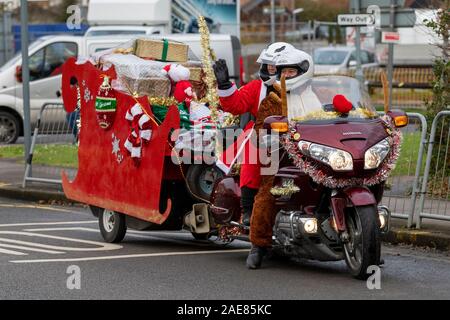 Chelmsford, Essex, Großbritannien. 7. Dez 2019. Biker gekleidet wie santa Besuch der Kinderstation in Broomfield Krankenhaus, um Weihnachtsgeschenke für Mitte der Essex Krankenhäuser Nächstenliebe Credit: Ricci Fothergill/Alamy Live News hand Stockfoto