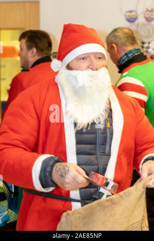 Chelmsford, Essex, Großbritannien. 7. Dez 2019. Biker gekleidet wie santa Besuch der Kinderstation in Broomfield Krankenhaus, um Weihnachtsgeschenke für Mitte der Essex Krankenhäuser Nächstenliebe Credit: Ricci Fothergill/Alamy Live News hand Stockfoto