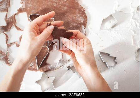 Traditionelle Weihnachten Lebkuchen backen. Cookies in Form von Gingerbread Man auf Papier zum Backen. Stockfoto