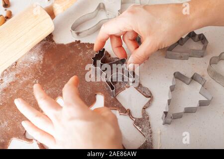 Traditionelle Weihnachten Lebkuchen backen. Cookies in Form von Gingerbread Man auf Papier zum Backen. Stockfoto