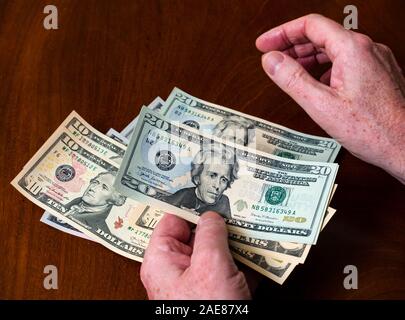 Mann zählen Amerikanische (US) Geld mit fünf, zehn und zwanzig Dollar Bills verfügt über US-Präsident Andrew Jackson Stockfoto