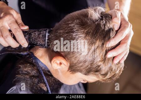 Kleinen Jungen bekommen einen Haarschnitt mit einer Schneidemaschine Stockfoto