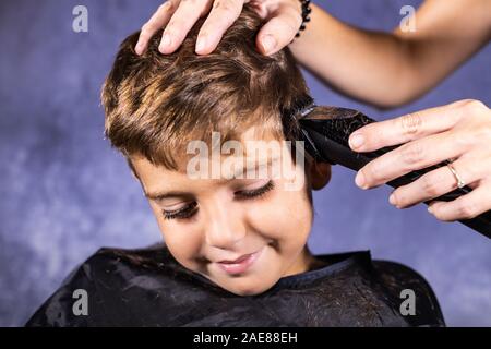 Kleinen Jungen bekommen einen Haarschnitt mit einer Schneidemaschine Stockfoto