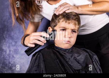 Kleinen Jungen bekommen einen Haarschnitt mit einer Schneidemaschine Stockfoto