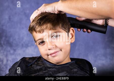 Kleinen Jungen bekommen einen Haarschnitt mit einer Schneidemaschine Stockfoto