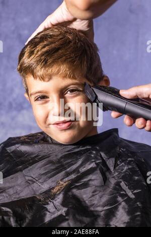 Kleinen Jungen bekommen einen Haarschnitt mit einer Schneidemaschine Stockfoto