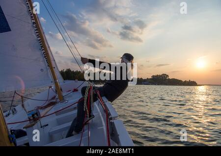 Ein Mann Segeln ein großes Boot auf dem Stausee Zegrze, Polen Stockfoto