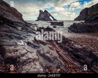 Der Blick von der felsigen Ufer zu den Bogen Geige Rock, Portknockie, Schottland Stockfoto