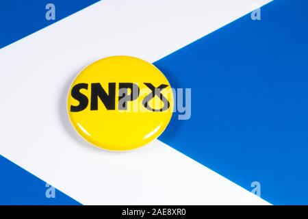 London, UK, 3. Dezember 2019: Scottish National Party pin Badge, dargestellt über die Schottland Flagge. Stockfoto