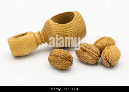 Nahaufnahme von Walnüssen und einem hölzernen Nussknacker auf weißem Hintergrund Stockfoto