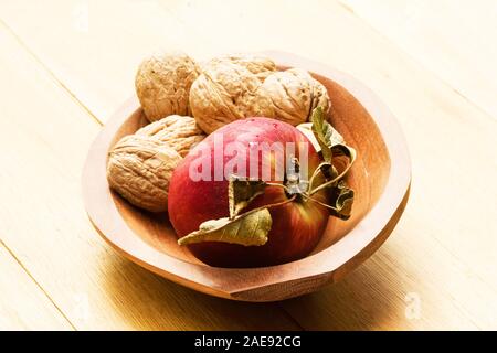 Noch immer leben von Apfel und Walnüsse in eine hölzerne Schüssel Stockfoto