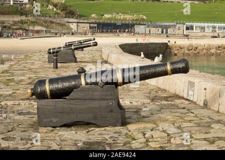 Kanonen auf der östlichen Wand von Lyme Regis Hafen. Lyme Regis ist auf der Heritage Coast oder Jurassic Coast gelegen, ist der Hafen von der geschützten Stockfoto