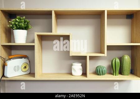 Home Innenausbau, Holz- Wandregal mit Objekten Komposition - Vase, dekorative Elemente aus Keramik, Topf mit Pflanze, retro style Radio Stockfoto