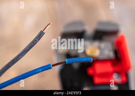 Elektrische Leitungen mit Kunststoffdämmung. Elektrisches Zubehör in der Industrie verwendet. Der dunkle Hintergrund. Stockfoto