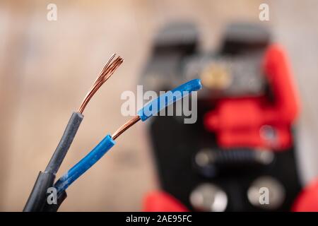 Elektrische Leitungen mit Kunststoffdämmung. Elektrisches Zubehör in der Industrie verwendet. Der dunkle Hintergrund. Stockfoto