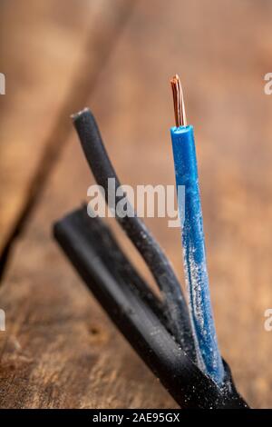 Elektrische Leitungen mit Kunststoffdämmung. Elektrisches Zubehör in der Industrie verwendet. Der dunkle Hintergrund. Stockfoto