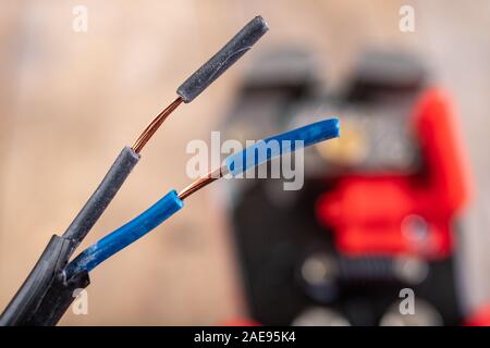 Elektrische Leitungen mit Kunststoffdämmung. Elektrisches Zubehör in der Industrie verwendet. Der dunkle Hintergrund. Stockfoto