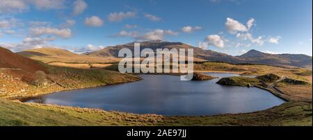 Panoramablick auf Llyn y Dywarchen, Snowdon, und Y Garn im Winter im Snowdonia National Park, North Wales. Stockfoto