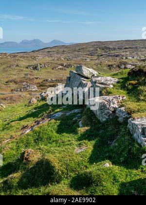 Die Reste der alten Bergfestung Steinmauer, Dun Cholla auf der Insel Colonsay mit der Paps Jura in der Ferne, Schottland, Großbritannien. Stockfoto