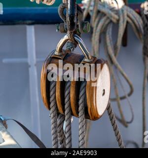 Nahaufnahme der hölzernen Block und Spanngeschirr Rigging von Flying Dutchman Schoner, ein traditionelles großes Segelschiff, Colonsay, Schottland, Großbritannien Stockfoto