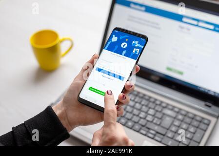 Sarajevo, Bosnien und Herzegowina - 7. Dezember 2019: Mädchen meldet sich das soziale Netzwerk Facebook per Telefon und Laptop Stockfoto