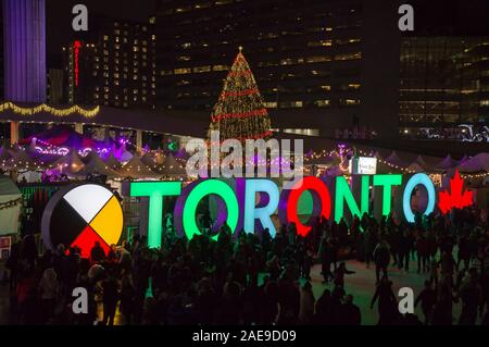 TORONTO, KANADA 12 23 2018: Nacht Blick auf Nathan Phillips Square in der kanadischen Stadt Toronto mit Menschen Spaß auf der Eisbahn in Stockfoto