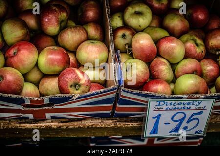 Boxen der Discovery Apples im Fruit Shop - unabhängige Familienfirma mit grünem Lebensmittelhändler in der ländlichen Berkshire - handschriftliches Preisschild. £1,95 /kg Stockfoto