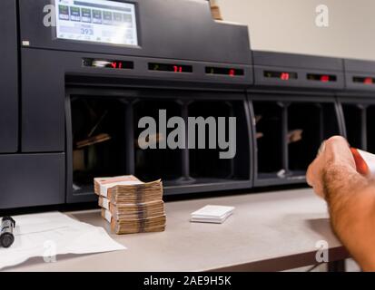 Banknoten gestapelt und zusammen mit Währung Bands vor der elektronischen Zählmaschine gebunden Stockfoto