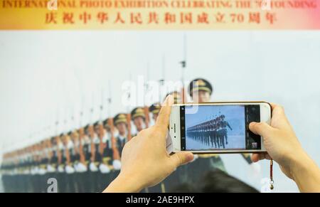 Toronto, Kanada. 7 Dez, 2019. Ein Besucher nimmt Bilder auf eine Foto- Ausstellung anlässlich des 70. Jahrestages der Gründung der Volksrepublik China (VRC) in Scarborough der Großraum Toronto, Kanada, Dez. 7, 2019. Die Foto- ausstellung in Scarborough am Samstag geöffnet. Credit: Zou Zheng/Xinhua/Alamy leben Nachrichten Stockfoto