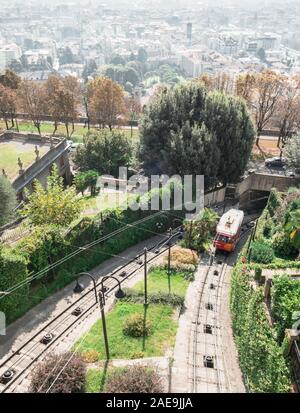 Obere Zeile in Bergamo Stadt Standseilbahn (funicolare Citta Alta). Rote Standseilbahn verbindet alte Obere Stadt und neu. Malerische Aussicht auf das historische Zentrum von Bergamo. Stockfoto