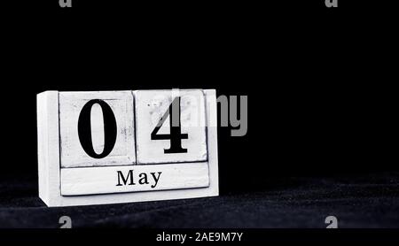 Am 4. Mai, 4. Mai, 4. Tag des Monats Mai - vintage Holz weiß Kalender Blöcke auf schwarzen Hintergrund mit leeren Raum für Text Stockfoto