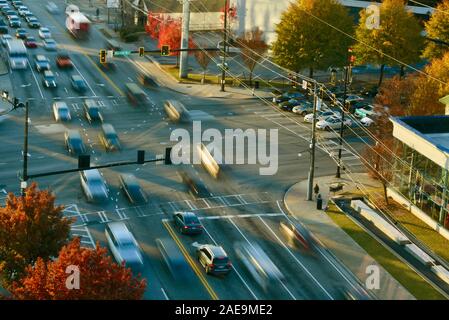 Am frühen Morgen pendeln Fahrzeug Verkehr (Motion Blur), verkehrsreichen Kreuzung, mit Menschen zu Fuß auf Fussgängerstreifen zu arbeiten, Buckhead, Atlanta, Georgia, USA. Stockfoto