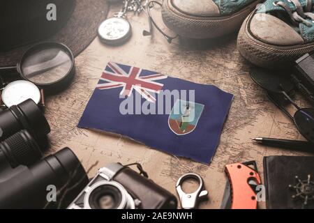 Montserrat Flagge zwischen Traveler Zubehör auf alten Vintage Karte. Reiseziel Konzept. Stockfoto