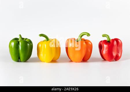 Farbige Paprika auf weißem Hintergrund. Grün, gelb, orange und rot Pfeffer. Essen Konzept. Frische reife Gemüse. Von der Seite. Stockfoto
