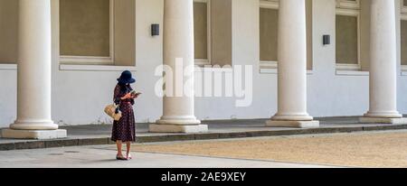 Frau mit Hut bedeckt Gesicht Blick auf ihr Handy im Stall Hof des Dresdner Schlosses Königliches Schloss Sachsen Deutschland. Stockfoto