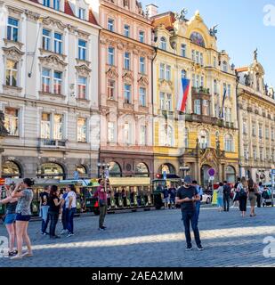 Mock-Trolley-Zug und Touristen vor dem ehemaligen Gebäude der Prager Stadtversicherung in der Altstadt Platz Prag Tschechische Republik. Stockfoto